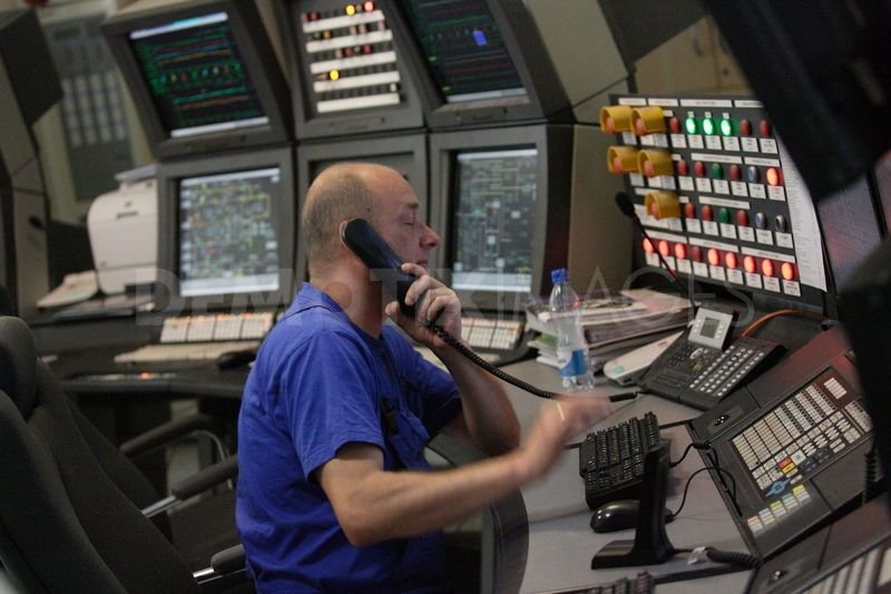 Modern oil refinery control center with grids of lights and buttons in front of the controller